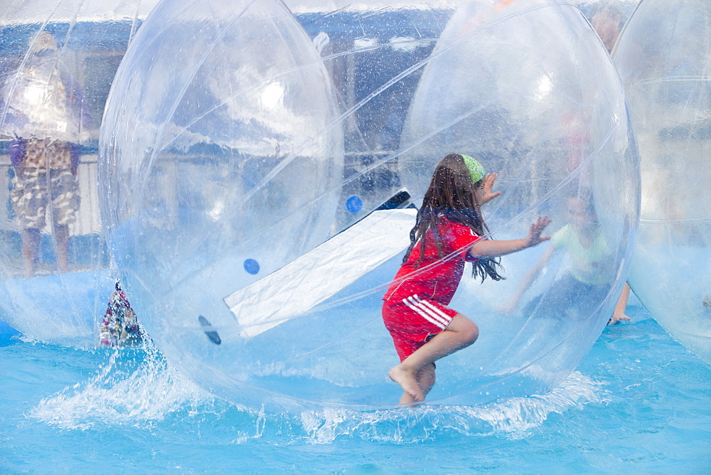 Children playing in water walkers on Llandudno Pier, North Wales, United Kingdom, Europe