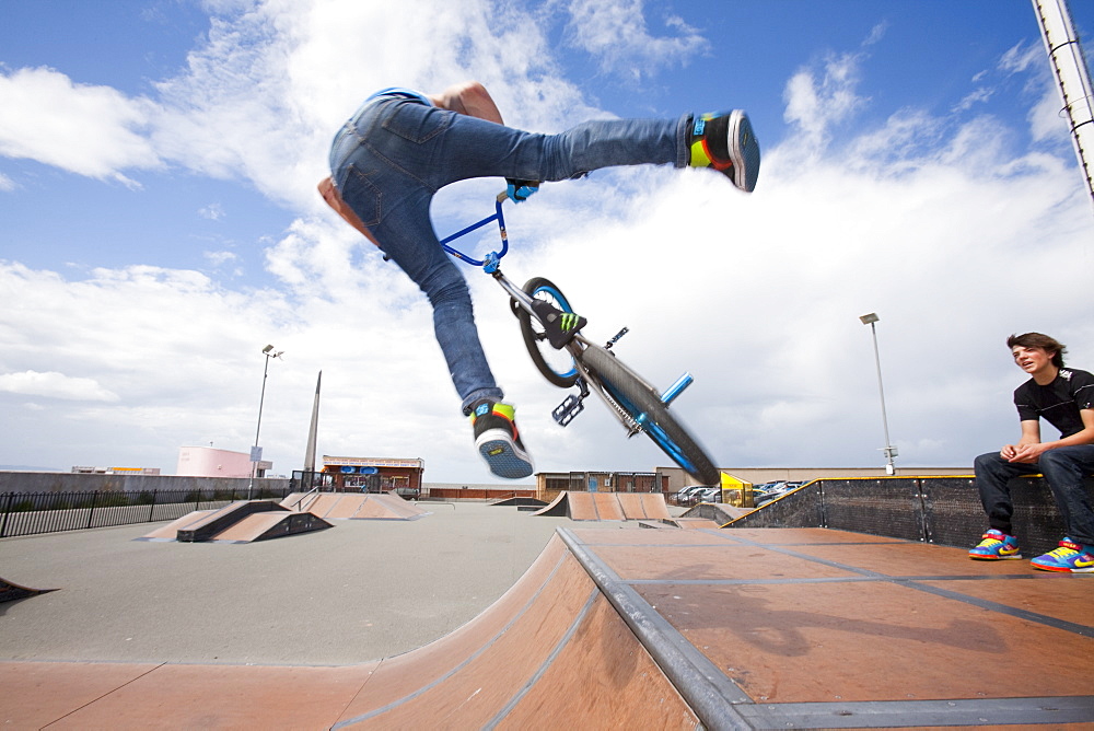 Teenage boys perform aerial stunts on BMX bikes at a BMX park in Rhyl, North Wales, United Kingdom, Europe