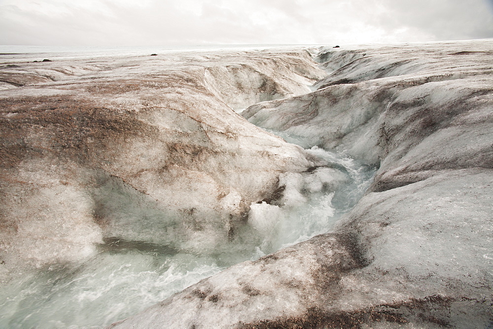 Meltwater on the Langjokull ice cap in Iceland disappearing into a moulin, Iceland, Polar Regions