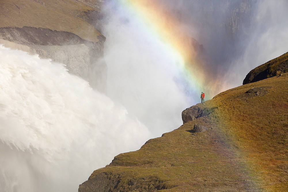 Rainbow and man by from the overspill from the Karahnjukar dam and Halslon reservoir, North East Iceland, Iceland, Polar Regions