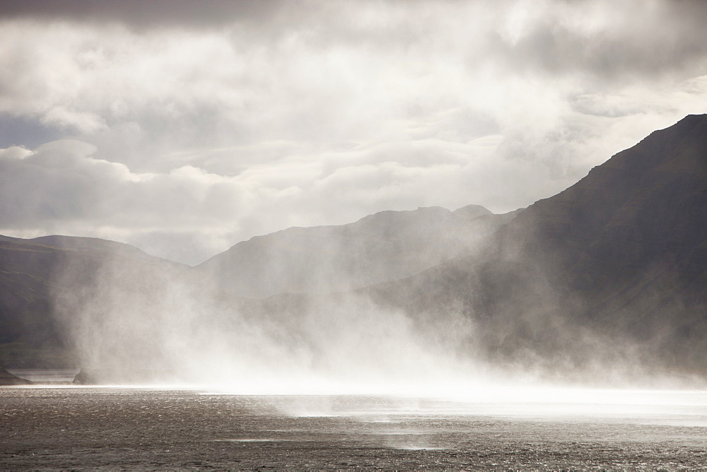 Storm force winds blowing spray off the sea in Hamarsfjordur on Icelands South Coast, Iceland, Polar Regions