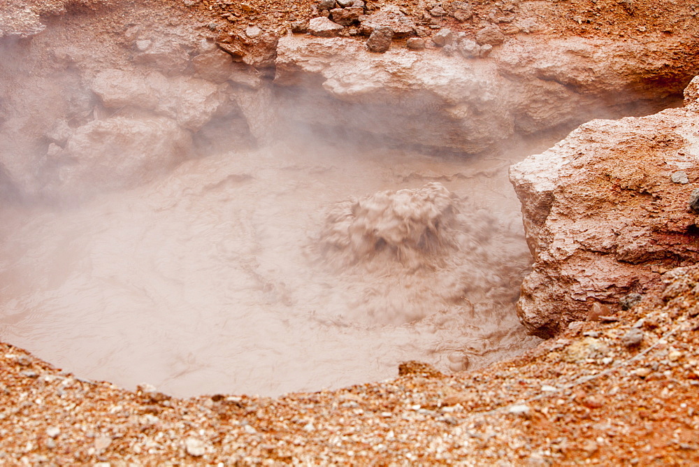 One of the many bubbling mud pools in a hot spring area on the outskirts of Hveragerdi, a geothermal hot spot, with steam rising from fumeroles right in the middle of town, South West Iceland, Polar Regions