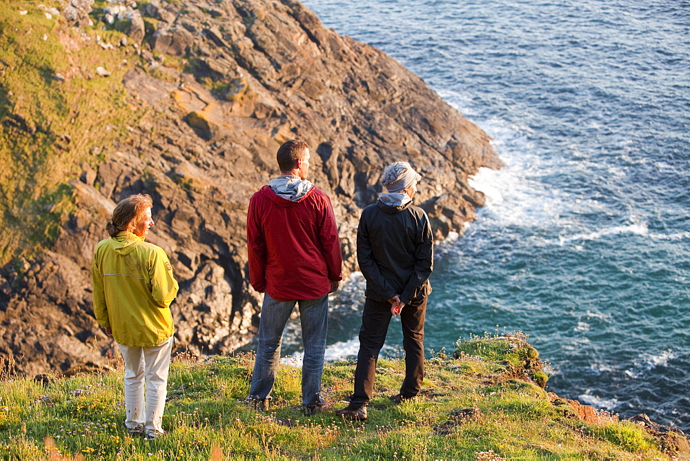 A group of walkers looking out to sea from Botallack on the Cornish coast, Cornwall, England, United Kingdom, Europe