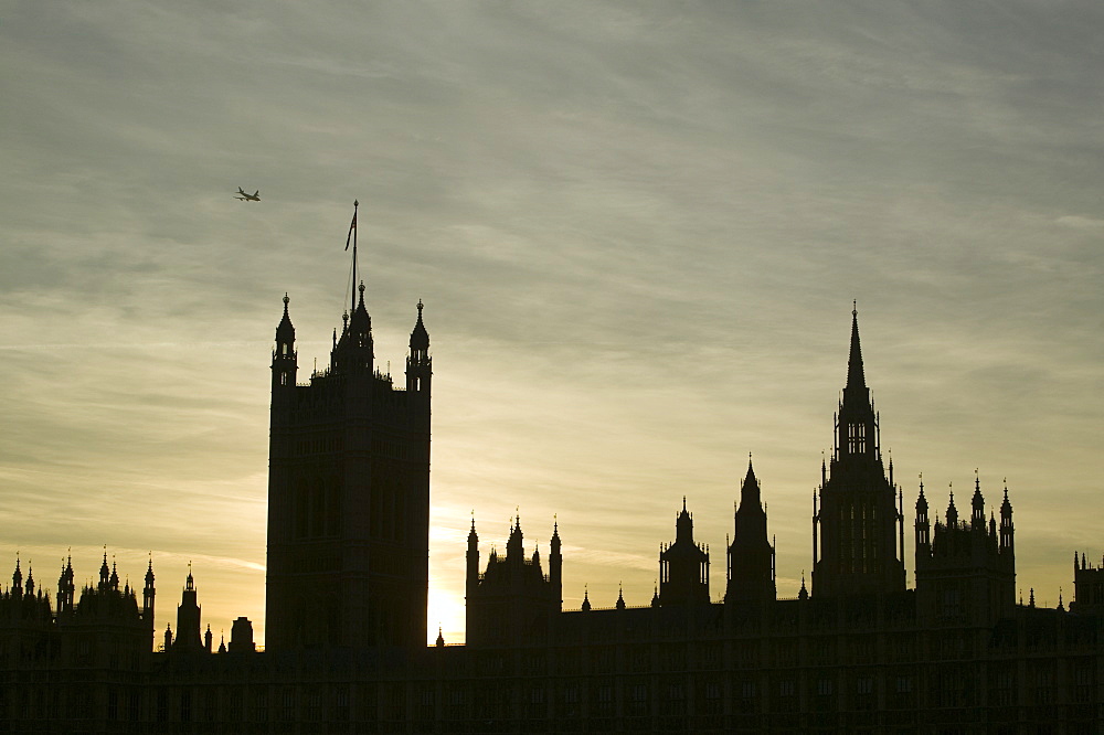 A plane flying over the Houses of Parliament, Westminster, London, England, United Kingdom, Europe