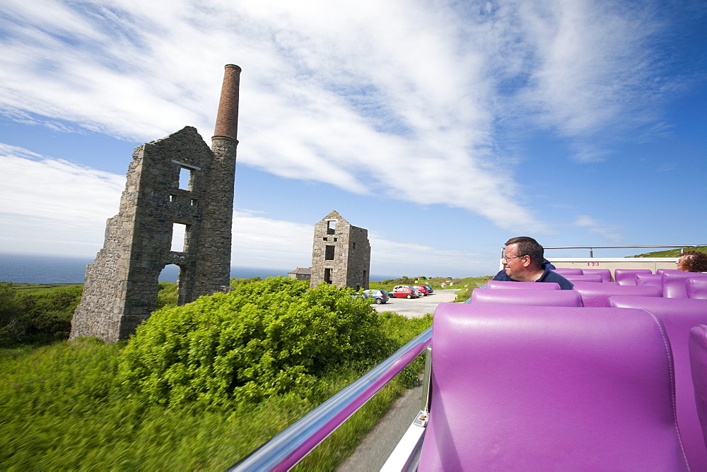 An open topped double decker bus travelling through the Cornish countryside and passing Bosigran tin mine, Cornwall, England, United Kingdom, Europe