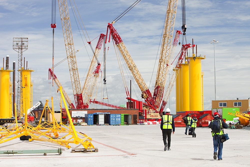 The yellow transition pieces that will hold the tower and turbine, that fit onto the monopile to hold the structure to the sea bed, Walney Offshore Wind Farm, Barrow in Furness, Cumbria, England, United Kingdom, Europe