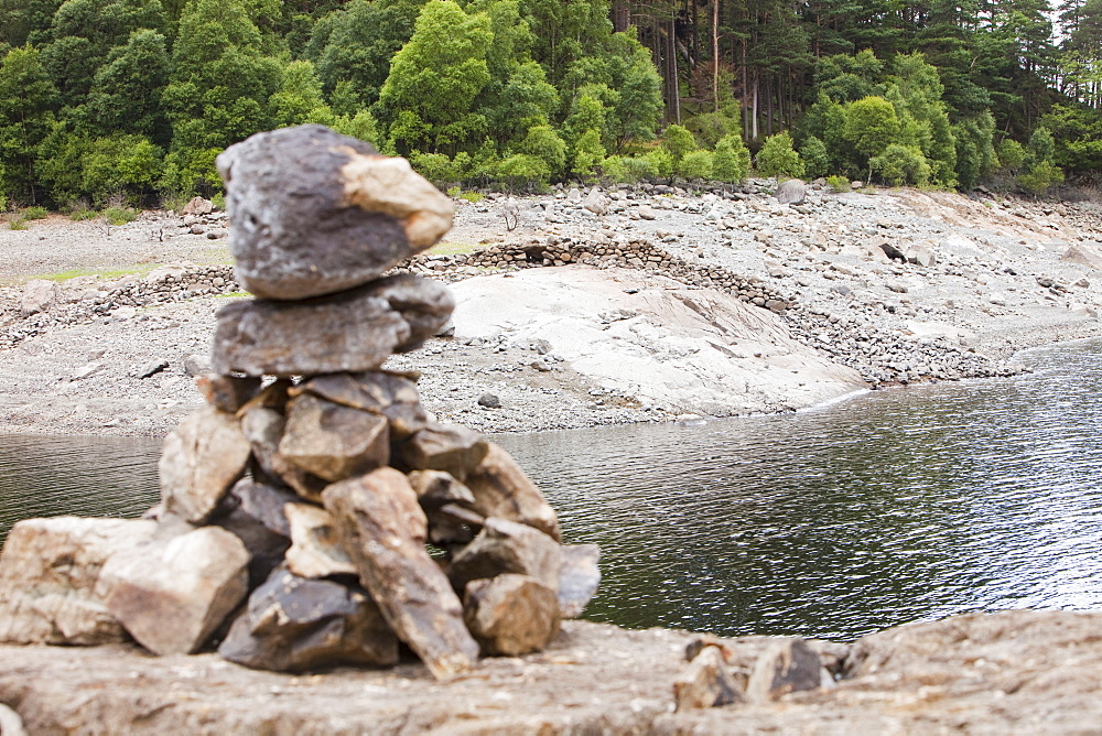 A cairn built on rocks that would noramlly be under water and a dry stone wall that was submerged when the reservoir was built. Thirlmere Reservoir, Lake District, Cumbria, England, United Kingdom, Europe