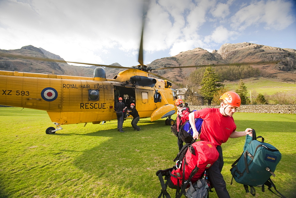 Members of Langdale Ambleside Mountain Rescue team exit an RAF Sea King helicopter during a rescue in Dungeon Ghyll in the Langdale Pikes, Lake District, Cumbria, England, United Kingdom, Europe