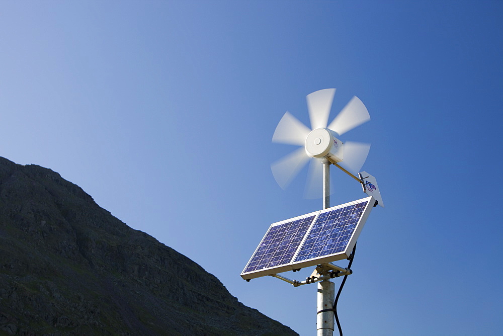 A solar electric panel and wind turbine being used to power a neon road sign on Kirkstone Pass, Lake District, Cumbria, England, United Kingdom, Europe