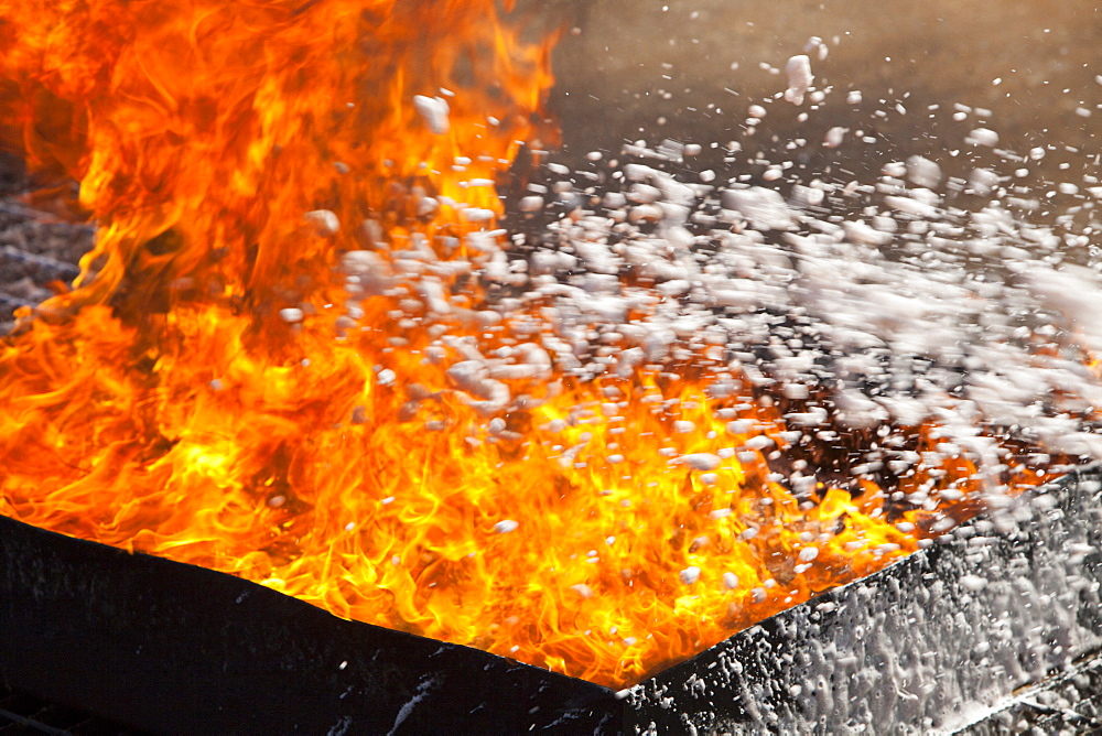 A foam extinguisher being used to put out a blaze in a.fire fighting exercise as part of a BOSIET course for offshore workers, Billingham, Teesside, England, United Kingdom, Europe