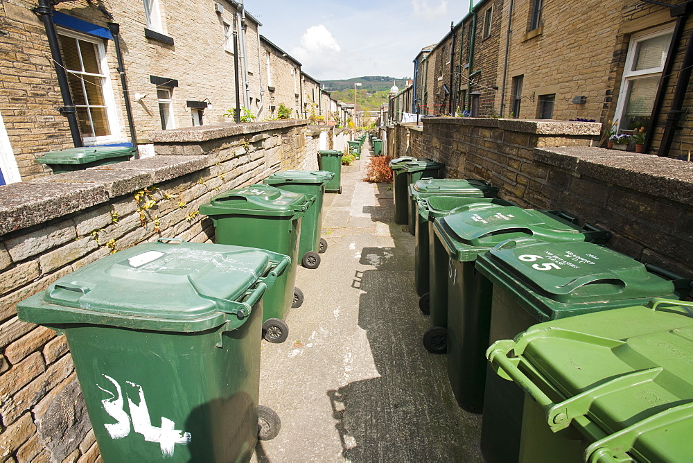 Rubbish bins on a back alley between terraced houses in Saltaire, Yorkshire, England, United Kingdom, Europe