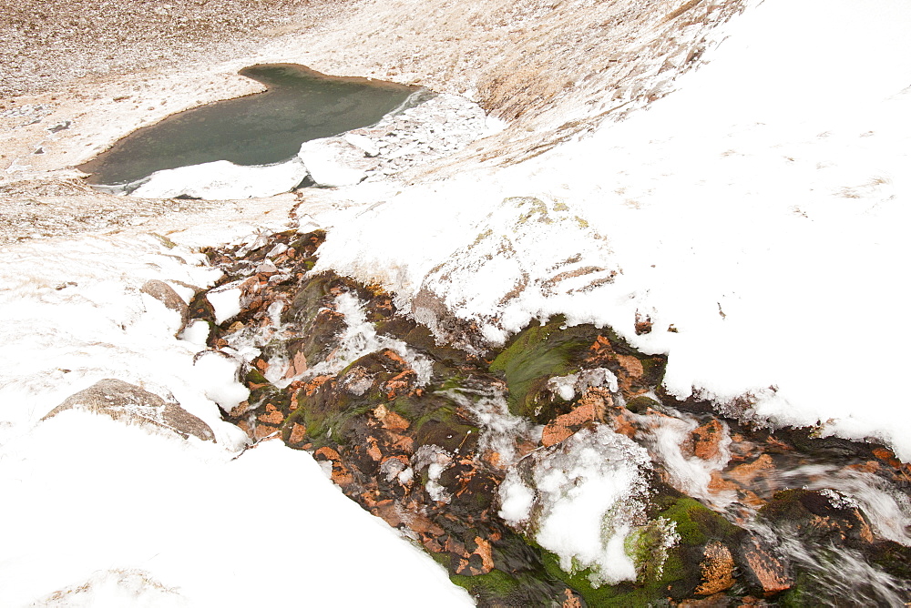 A hole caused by a snow bank collapsing over the top of a stream in Coire an Lochain in the Cairngorm mountains, Scotland, United Kingdom, Europe