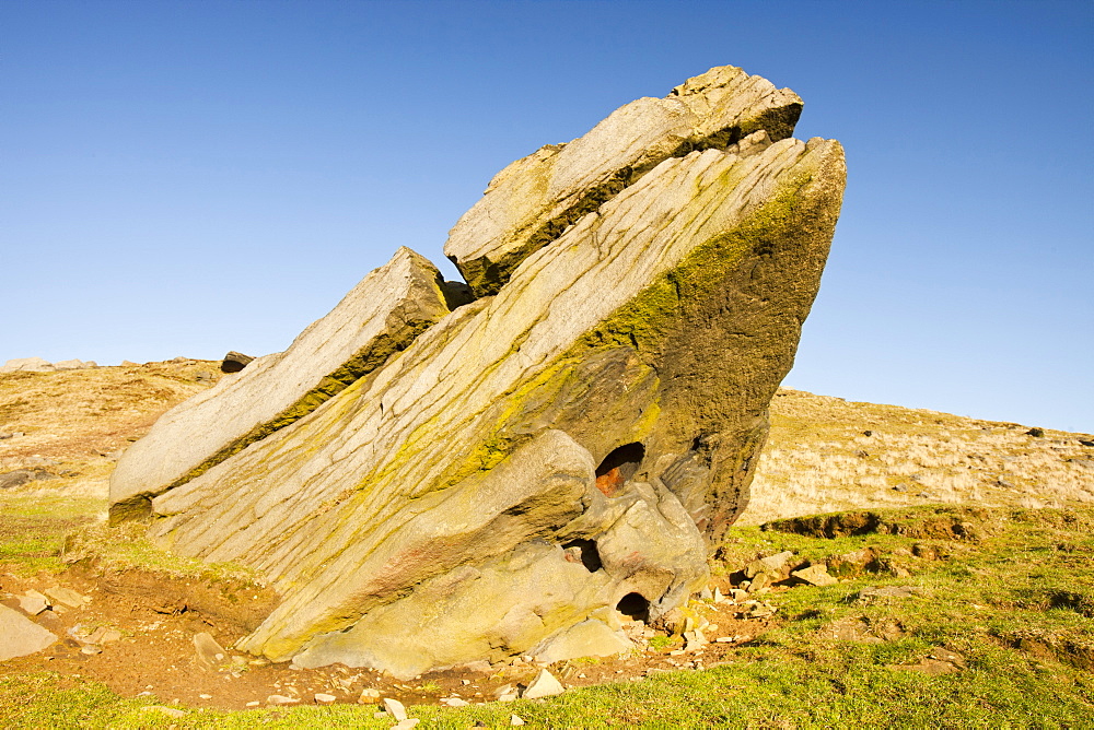 A boulder of millstone grit on Ilkley moor with a perfect circular hole probably formed by a large inclusion weathered out of the bedrock, West Yorkshire, England, United Kingdom, Europe