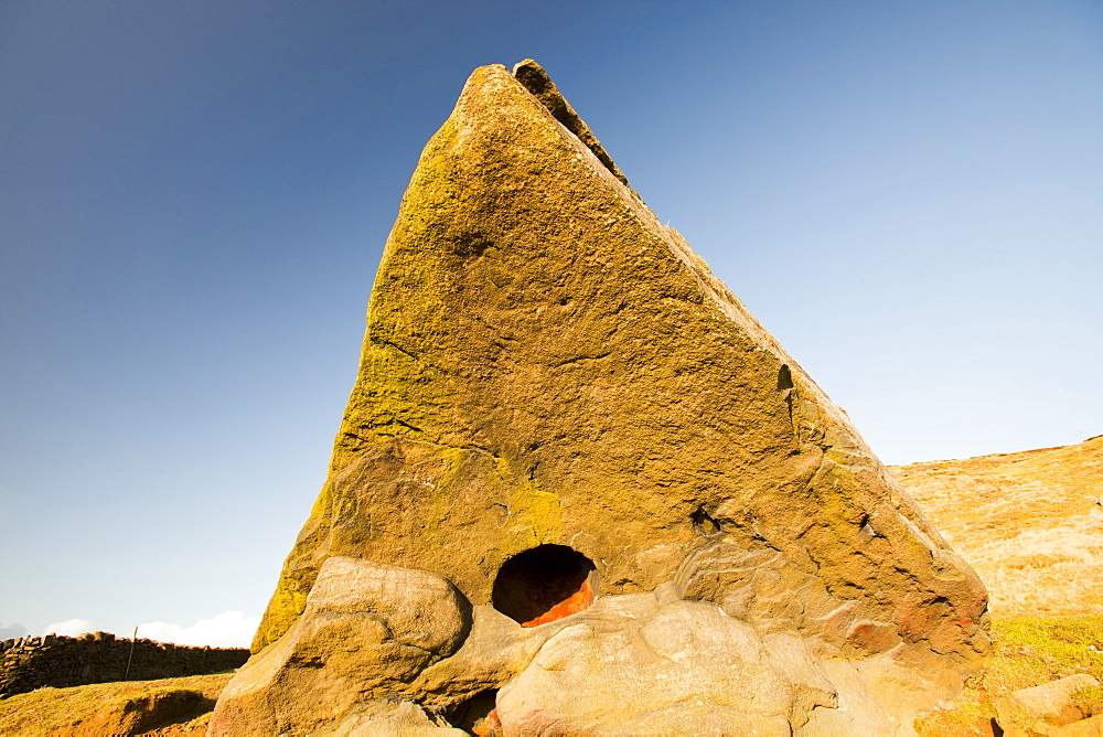 A boulder of millstone grit on Ilkley moor with a perfect circular hole probably formed by a large inclusion weathered out of the bedrock, West Yorkshire, England, United Kingdom, Europe