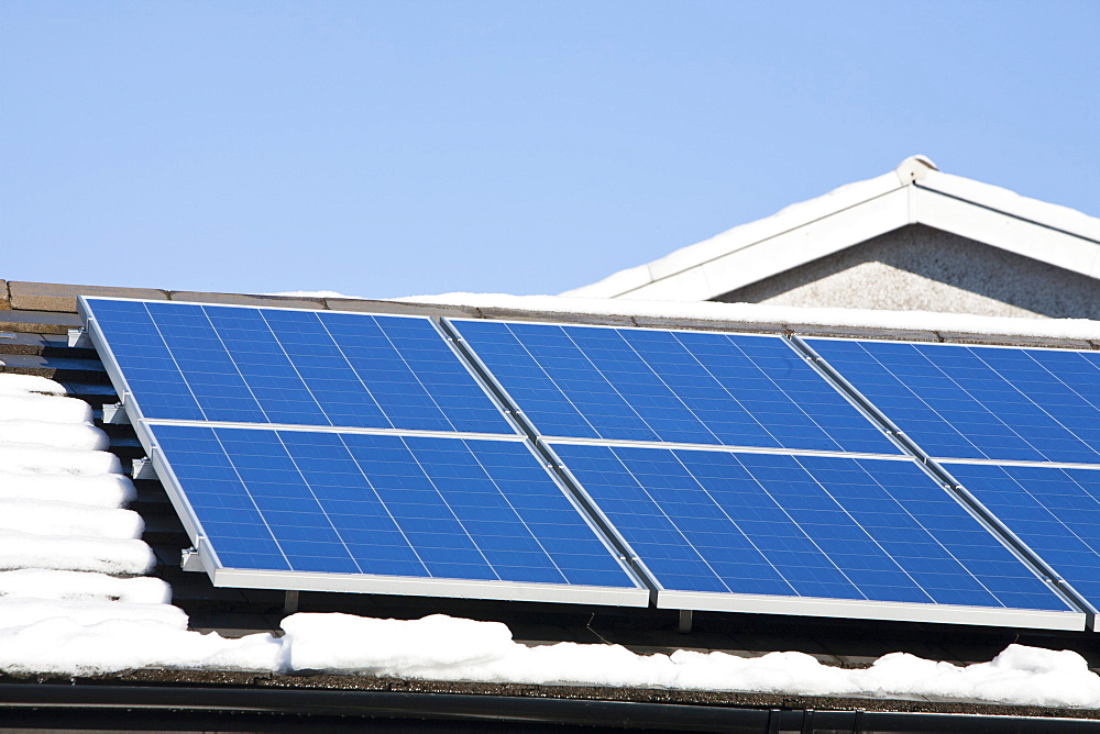 Solar panels on a house roof in Ambleside in the snow, Lake District, Cumbria, England, United Kingdom, Europe