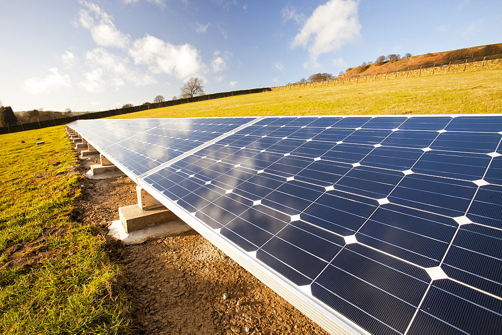 Solar panels in a field behind a farm house powered by them on the edge of Ilkley Moor, West Yorkshire, Yorkshire, England, United Kingdom, Europe