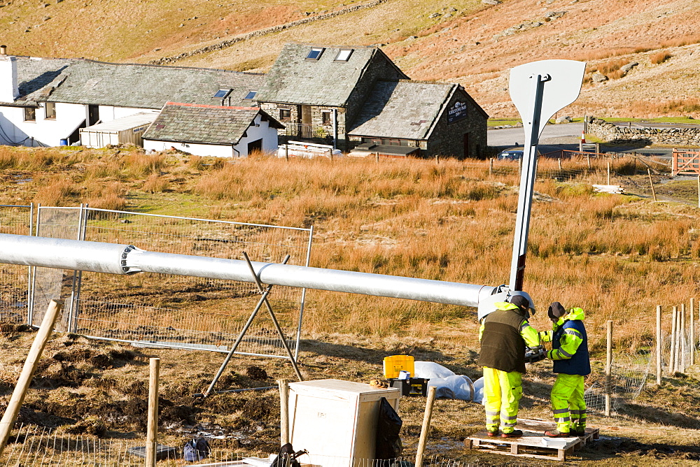 Three wind turbines being constructed behind the Kirkstone Pass Inn on Kirkstone Pass in the Lake District, Cumbria, England, United Kingdom, Europe