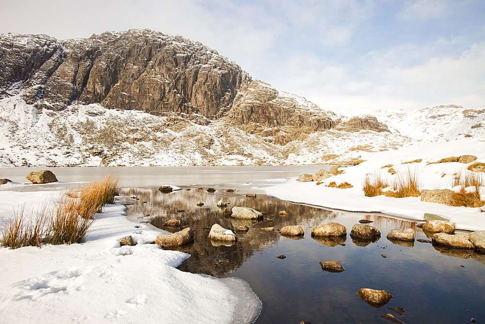 A frozen Stickle Tarn above the Langdale Valley with Pavey Ark in the background, Lake District, Cumbria, England, United Kingdom, Europe