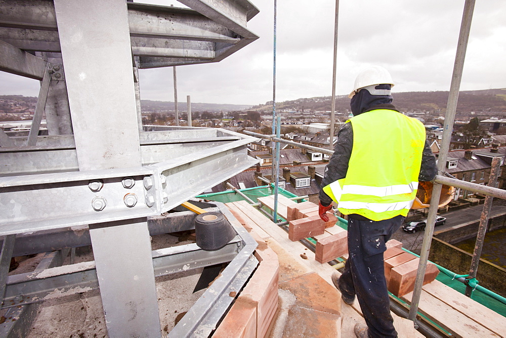 A stone mason working on the minaret of a new mosque being built in Keighley, West Yorkshire, Yorkshire, England, United Kingdom, Europe