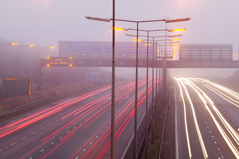 Cars driving in evening fog on the M1 motorway near Loughborough, Leicestershire, England, United Kingdom, Europe