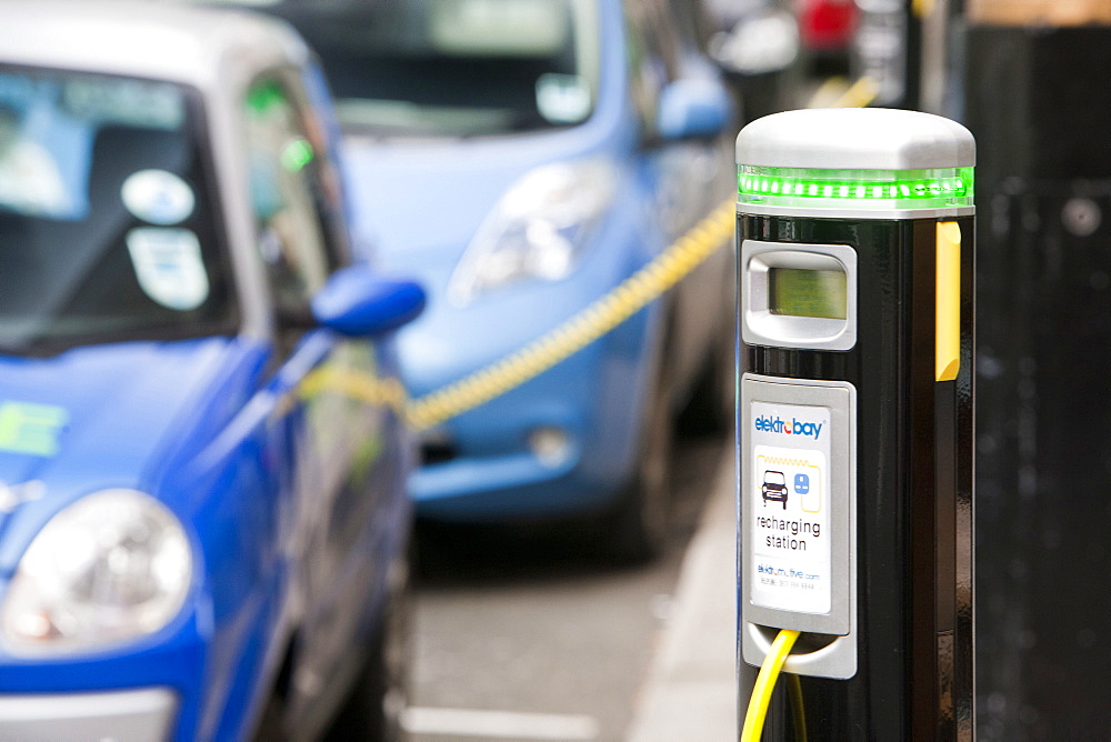 A row of electric vehicles at recharging stations on the street in Berkeley Square, London, England, United Kingdom, Europe