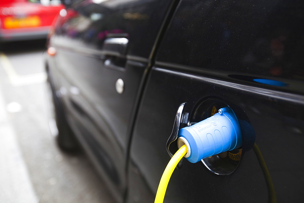 An electric vehicle at a recharging station on the street in Berkeley Square, London, England, United Kingdom, Europe