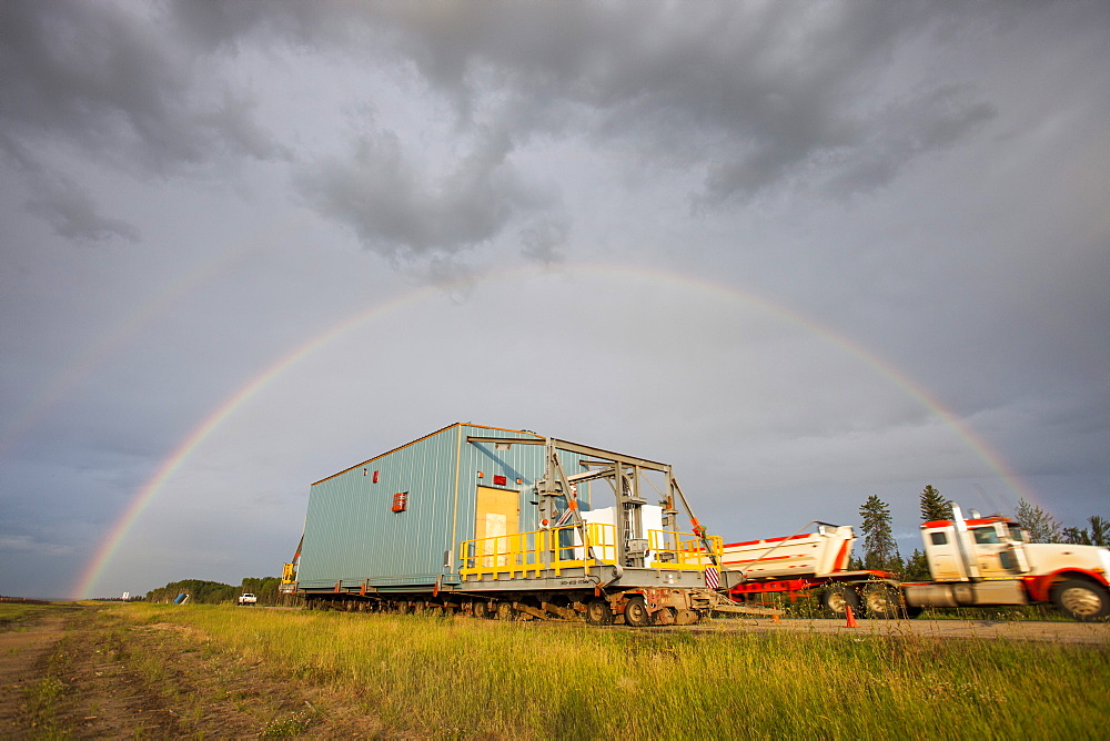 Trucks haul an oversize load of tar sands equipment on the road towards Fort McMurray, the centre of the tar sands industry, Alberta, Canada, North America