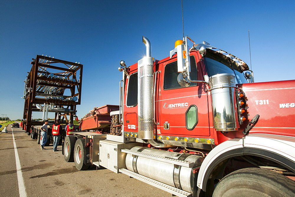 Trucks haul an oversize load of tar sands equipment for a SAGD mine, on the road towards Fort McMurray, the centre of the tar sands industry, Alberta, Canada, North America