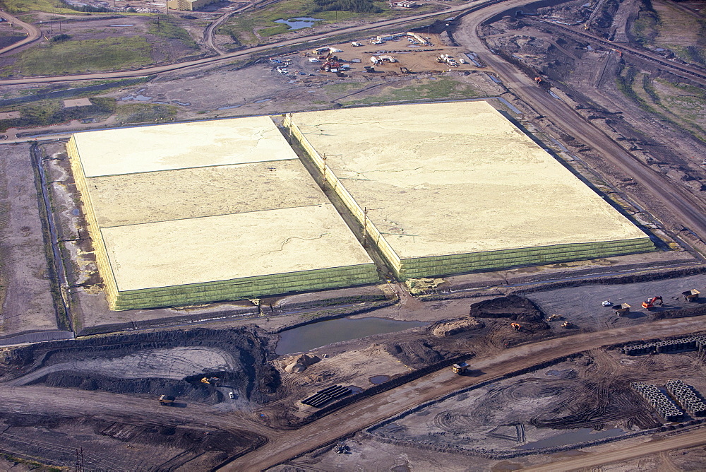 Sulphur which has to be extracted from the raw bitumen from tar sands piled up in huge mountains by the Syncrude upgrader plant near Fort McMurray, Alberta, Canada, North America