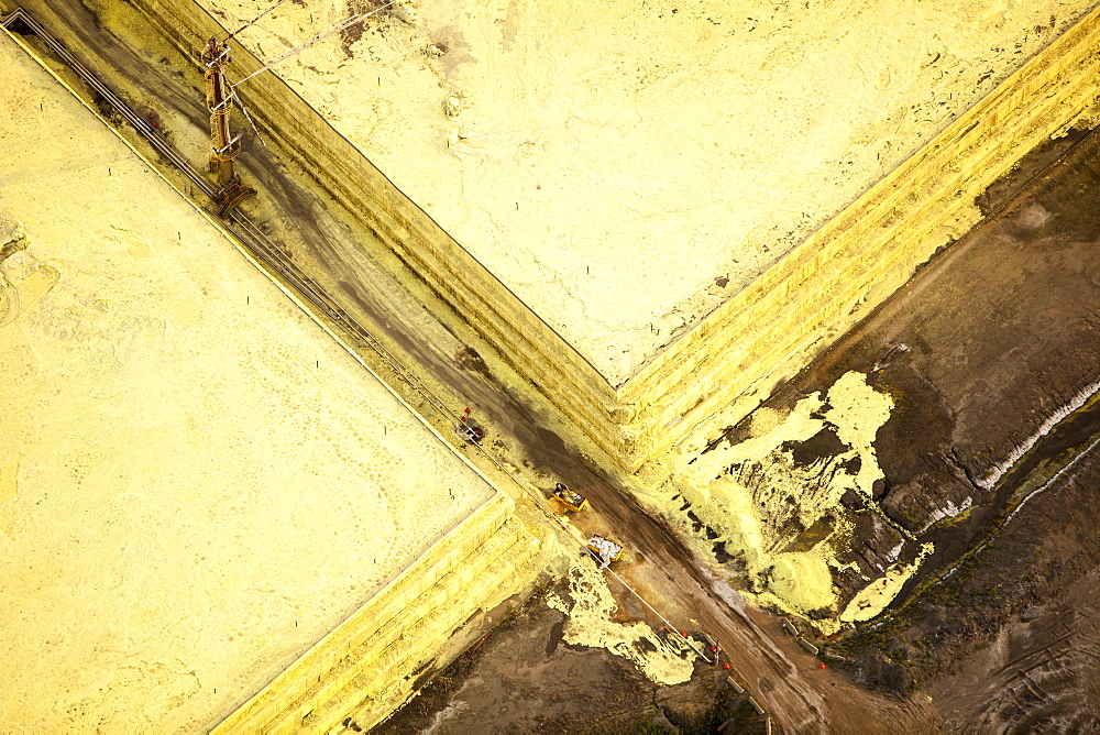 Sulphur which has to be extracted from the raw bitumen from tar sands piled up in huge mountains by the Syncrude upgrader plant near Fort McMurray, Alberta, Canada, North America