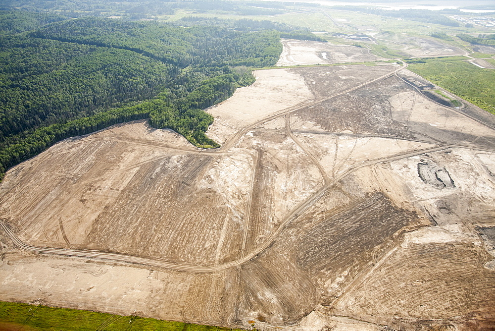 Soil overburden being removed to reach the tar sands beds in an open pit tar sands mine north of Fort McMurray, Alberta, Canada, North America