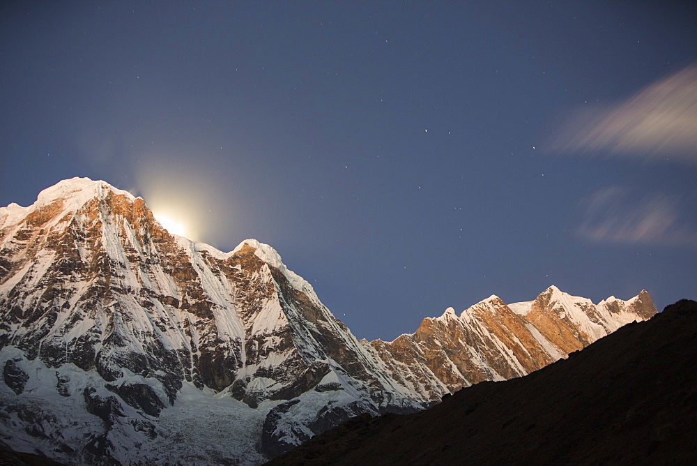 The night sky over Annapurna South and Annapurna Fang in the Annapurna Sanctuary, with the glow from the setting moon behind the peak, Himalayas, Nepal, Asia