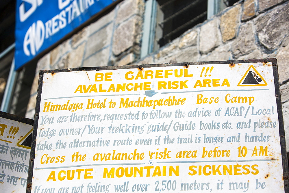 A sign about avalanche risk and acute mountain sickness in the Annapurna Sanctuary, Himalayas, Nepal, Asia