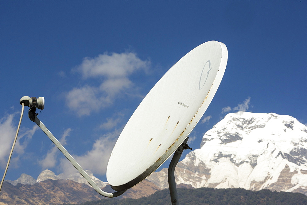 A satellite dish in front of Annapurna South summit, Annapurna Sanctuary, Himalayas, Nepal, Asia