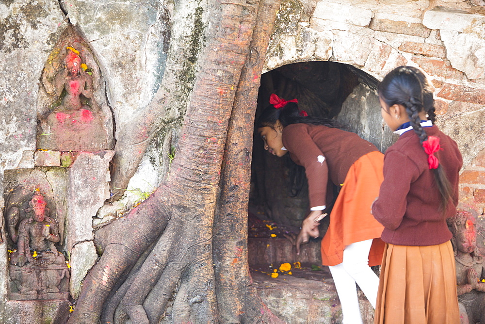 School girls make an offering at a Hindu temple in Durbar Square, UNESCO World Heritage Site, Kathmandu, Nepal, Asia