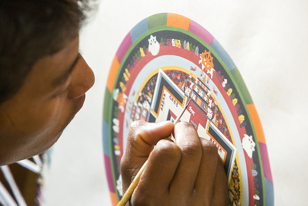 A Buddist artist painting a traditional Thanka painting at the Boudhanath Stupa, one of the holiest Buddhist sites in Kathmandu, Nepal, Asia