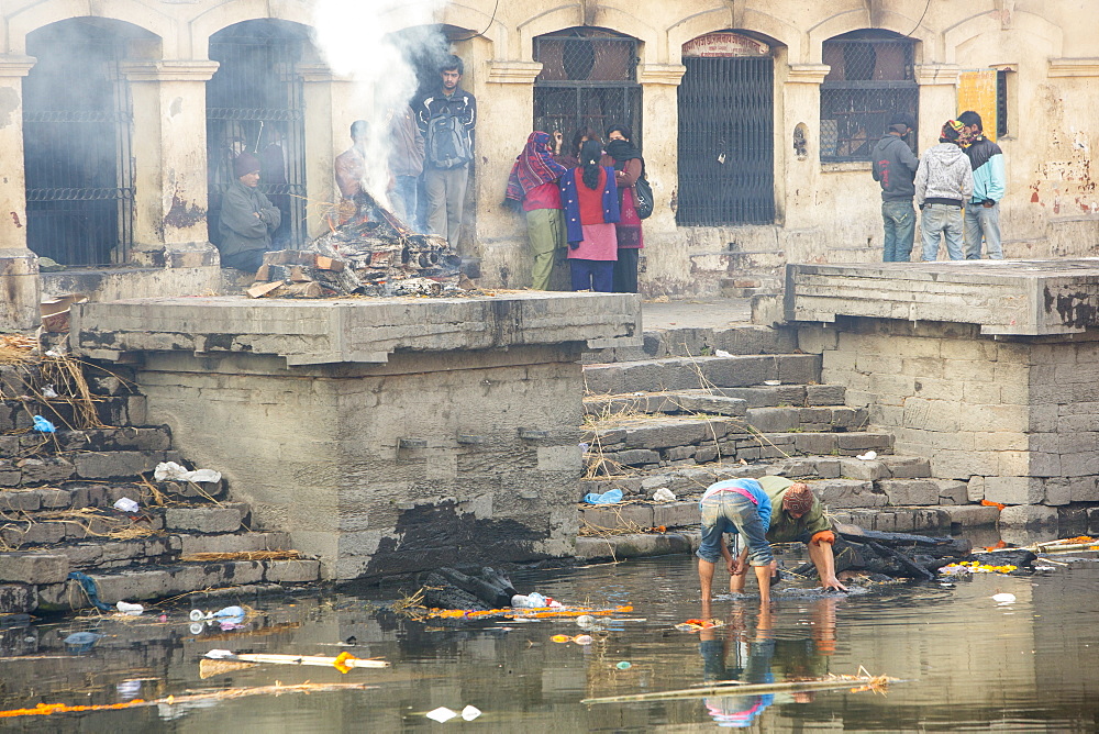 Boys panning in the Bagmati River for gold from teeth and jewellery, after the remains of funeral pyres are tipped into the river, Pashupatinath Temple, UNESCO World Heritage Site, Kathmandu, Nepal, Asia