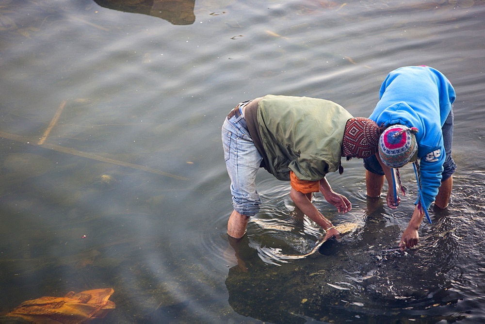 Boys panning in the Bagmati River for gold from teeth and jewellery, after the remains of funeral pyres are tipped into the river, Pashupatinath Temple, UNESCO World Heritage Site, Kathmandu, Nepal, Asia