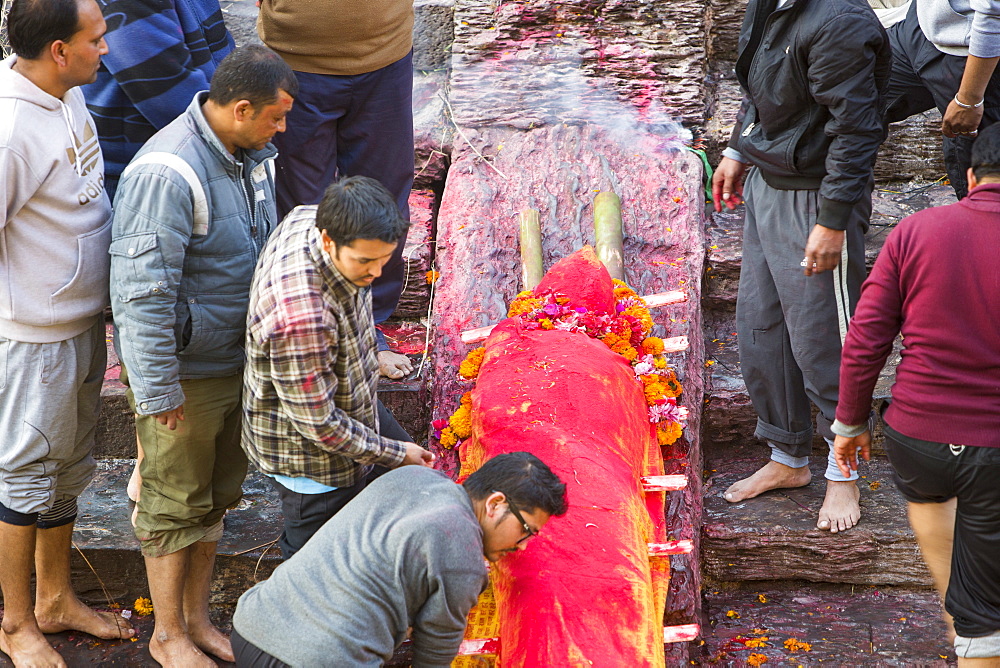 Family preparing a body for cremation at the Pashupatinath Temple, a Hindu temple of Lord Shiva located on the banks of the Bagmati River Kathmandu, Nepal, Asia