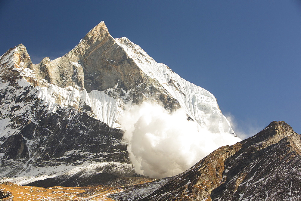 An avalanche on Machapuchare (Fishtail Peak) in the Annapurna Himalaya, Nepal, Asia