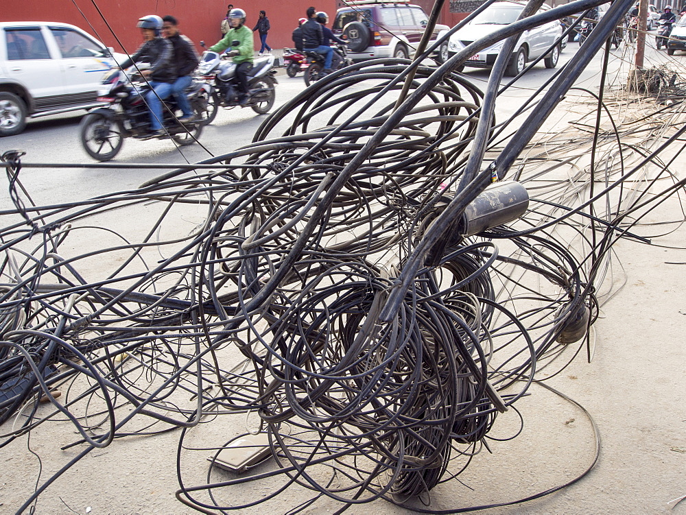 An electrician works on a tangle of electric wires in Kathmandu, Nepal, Asia