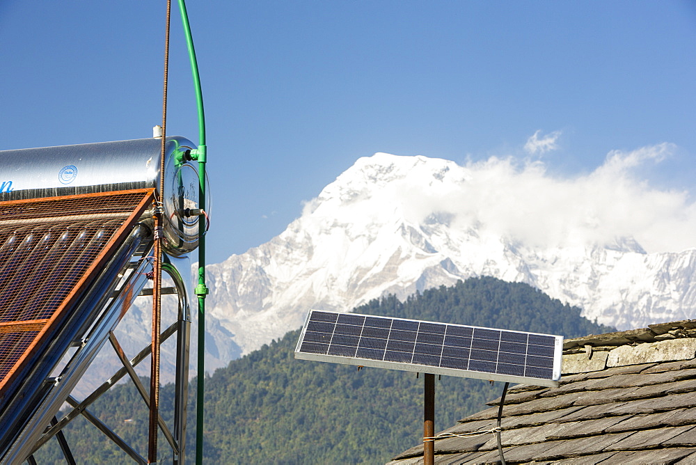 Solar thermal panels for heating water with solar photo voltaic panels on the rooftops of a tea house in the Himalayan foothills, Nepal, Asia