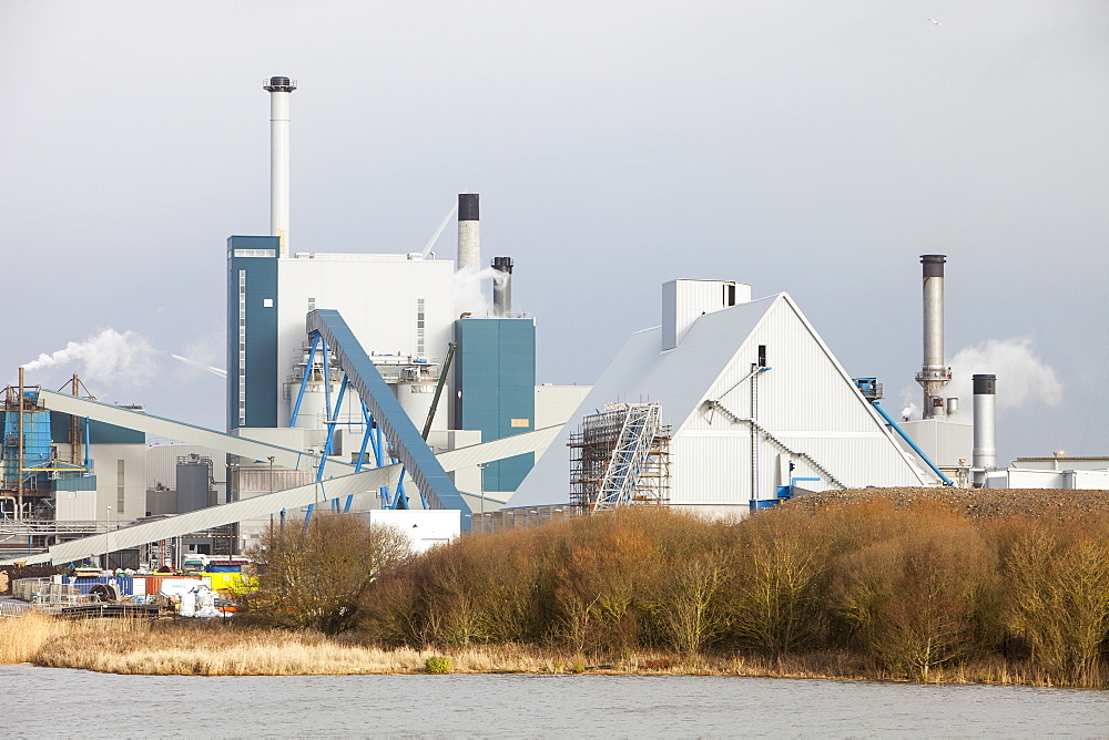 The new biofuel power plant at the Iggesund paper board manufacturer, with wind turbines behind, Workington, Cumbria, England, United Kingdom, Europe