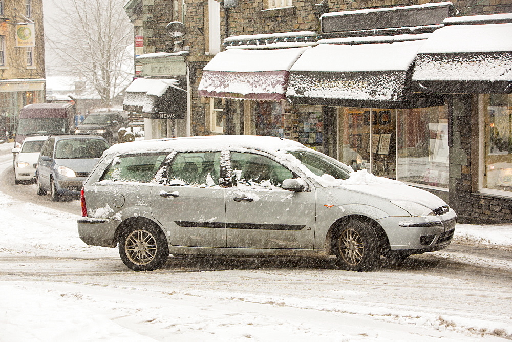 Cars driving through heavy snow in Ambleside, Lake District, Cumbria, England, United Kingdom, Europe