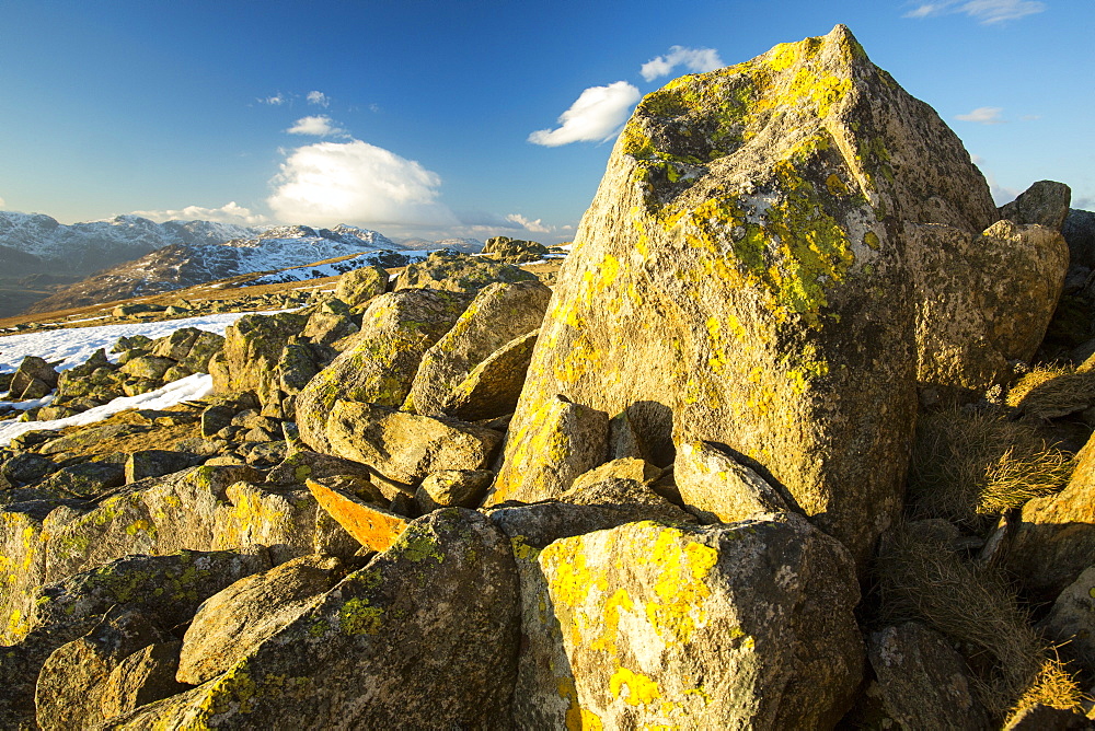 Lichen covered rocks on Swirl Howe above Wrynose, looking towards Langdale and the Scafell range, Lake District National Park, Cumbria, England, United Kingdom, Europe