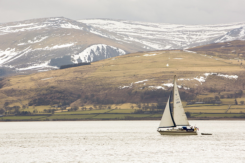 A sailing boat sailing up the Menai Straits off Beaumaris on Anglesey, Wales, United Kingdom, Europe