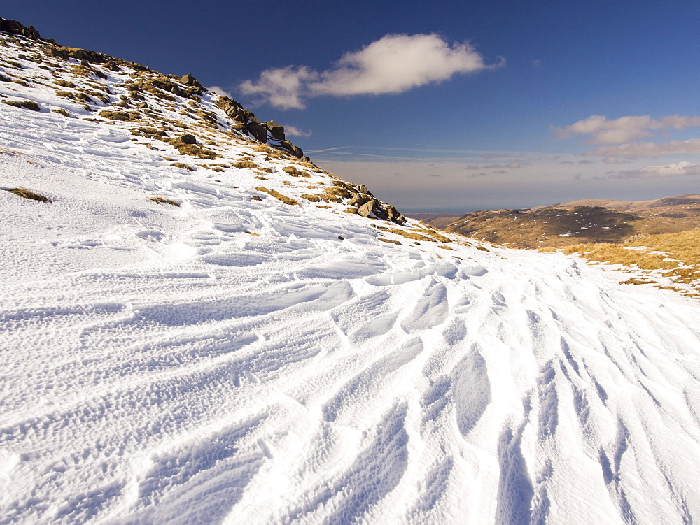 Snow shaped and scoured by a strong wind when it fell, above Wrynose Pass in the Lake District, Cumbria, England, United Kingdom, Europe