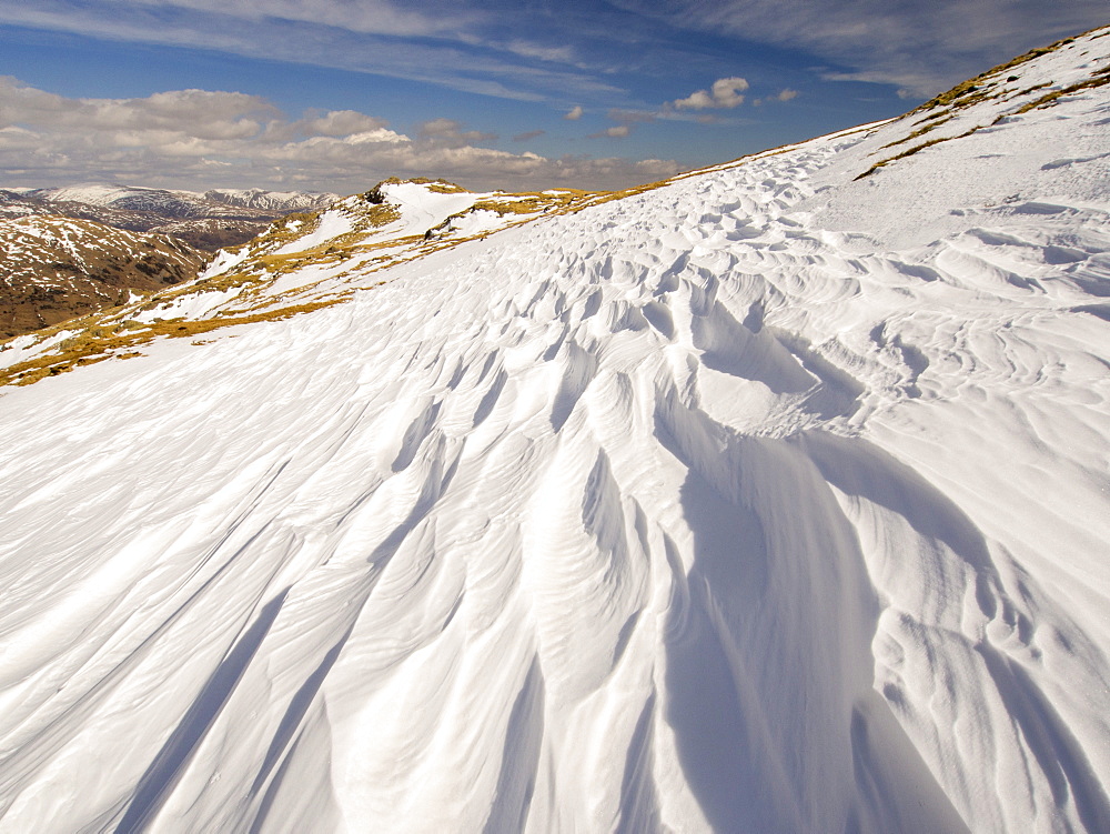 Snow shaped and scoured by a strong wind when it fell, above Wrynose Pass in the Lake District, Cumbria, England, United Kingdom, Europe