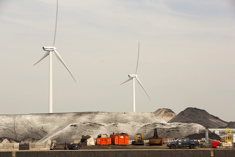 Climate change heaven and hell, wind turbines next to a coal importing business on the docks in Amsterdam, Netherlands, Europe