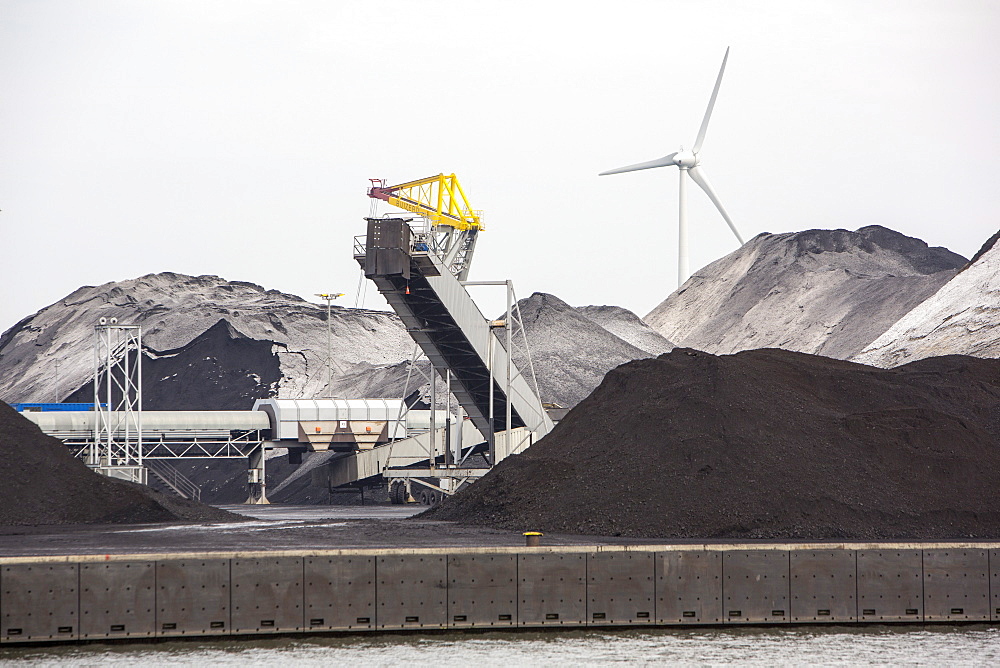 Climate change heaven and hell, wind turbines next to a coal importing business on the docks in Amsterdam, Netherlands, Europe